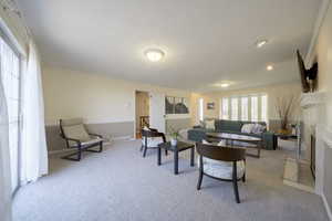 Living room featuring crown molding, light carpet, and a textured ceiling