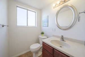 Half bathroom featuring vanity and light tile patterned floors