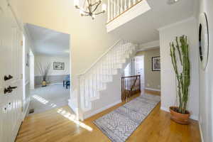 Entrance foyer featuring crown molding, light wood-style floors, and a chandelier