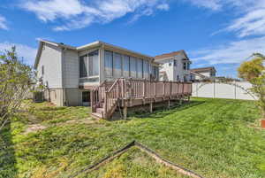 Back of house with a sunroom, a fenced backyard, and a deck