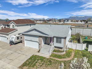 View of front facade featuring a garage, roof with shingles, driveway, a residential view, and a mountain view