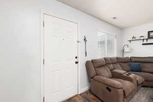 Living room with dark wood-style flooring and baseboards