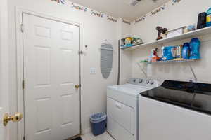 Laundry room featuring separate washer and dryer and a textured ceiling