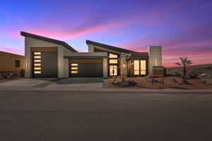 Modern home with a garage, driveway, and stucco siding
