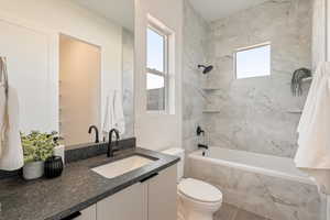 Full bath featuring tiled shower / bath combo and vanity