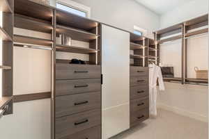 Walk in closet with light colored carpet