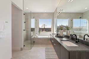 Full bath with double vanity, a bath, a stall shower, and recessed lighting