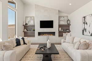 Living area with a tile fireplace, vaulted ceiling, wood finished floors, and recessed lighting