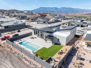Aerial view of residential area featuring a mountainous background and a pool area