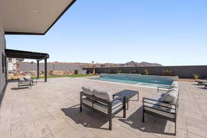 View of swimming pool with patio surround, an outdoor lounge area, a fenced backyard, and a mountain view