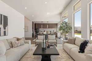 Living room with vaulted ceiling, light wood-type flooring, and recessed lighting