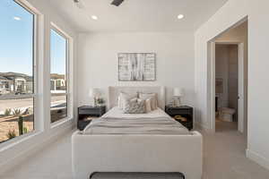 Bedroom with light colored carpet, recessed lighting, ensuite bathroom, and ceiling fan
