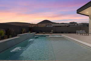 View of swimming pool with a fenced backyard, a mountain view, and patio surround