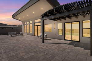 Patio terrace at dusk with a pergola, a patio, and outdoor furniture