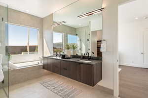 Bathroom featuring a stall shower, double vanity, a garden tub, and recessed lighting
