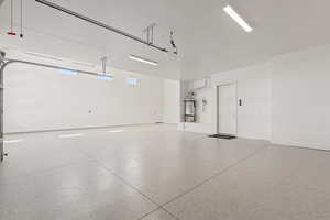 Garage featuring water heater and baseboards