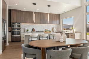 Kitchen with light stone countertops, modern cabinets, stainless steel appliances, and decorative backsplash