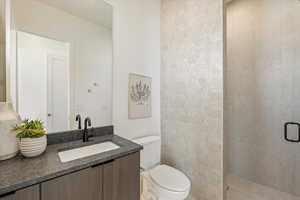 Full bath featuring a stall shower and vanity