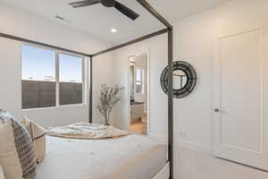 Bedroom featuring light colored carpet, ceiling fan, multiple windows, ensuite bath, and recessed lighting