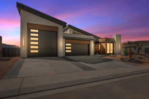 Modern home with a garage, driveway, and brick siding