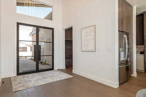 Entryway with dark wood finished floors and a high ceiling