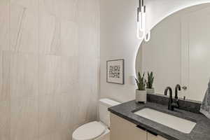 Half bathroom with vanity and toilet