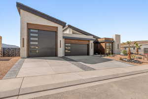 Contemporary house featuring driveway, a garage, and brick siding