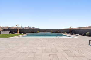 View of swimming pool featuring a fenced backyard and patio surround