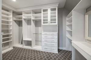 Walk in closet featuring dark colored carpet