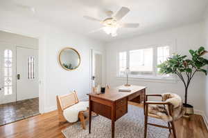 Office area featuring a ceiling fan, wood finished floors, and crown molding