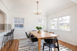 Dining room with wood finished floors and suspended lighting