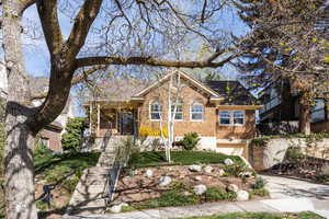 View of front of house with a garage, brick siding, and driveway