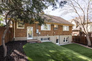 Back of house featuring brick siding, a fenced backyard, and a chimney
