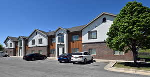 View of building exterior featuring uncovered parking and a residential view