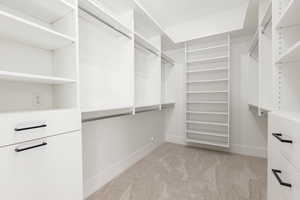 Walk in closet featuring light carpet
