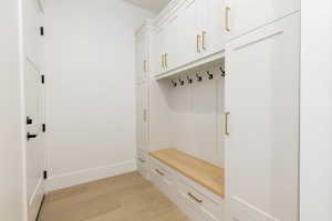 Mudroom featuring light wood finished floors and baseboards