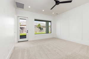 Empty room featuring a decorative wall, light carpet, recessed lighting, and a ceiling fan