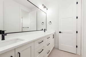Bathroom with double vanity and light tile patterned flooring