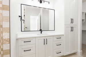 Bathroom with vanity and a walk in closet