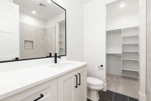 Bathroom with vanity, a walk in closet, recessed lighting, and light tile patterned floors