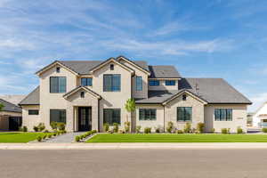 View of front of home featuring a front lawn, a tiled roof, stucco siding, and stone siding