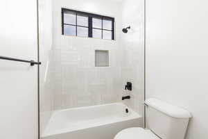 Full bath featuring toilet and bathing tub / shower combination