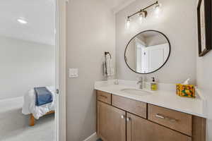 Bathroom featuring vanity, carpet flooring, and ensuite bathroom