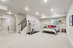 Bedroom featuring light carpet, a textured ceiling, and recessed lighting
