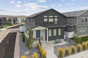 View of front facade with a residential view, a shingled roof, and a porch
