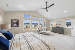 Carpeted bedroom featuring a ceiling fan, recessed lighting, and a high ceiling