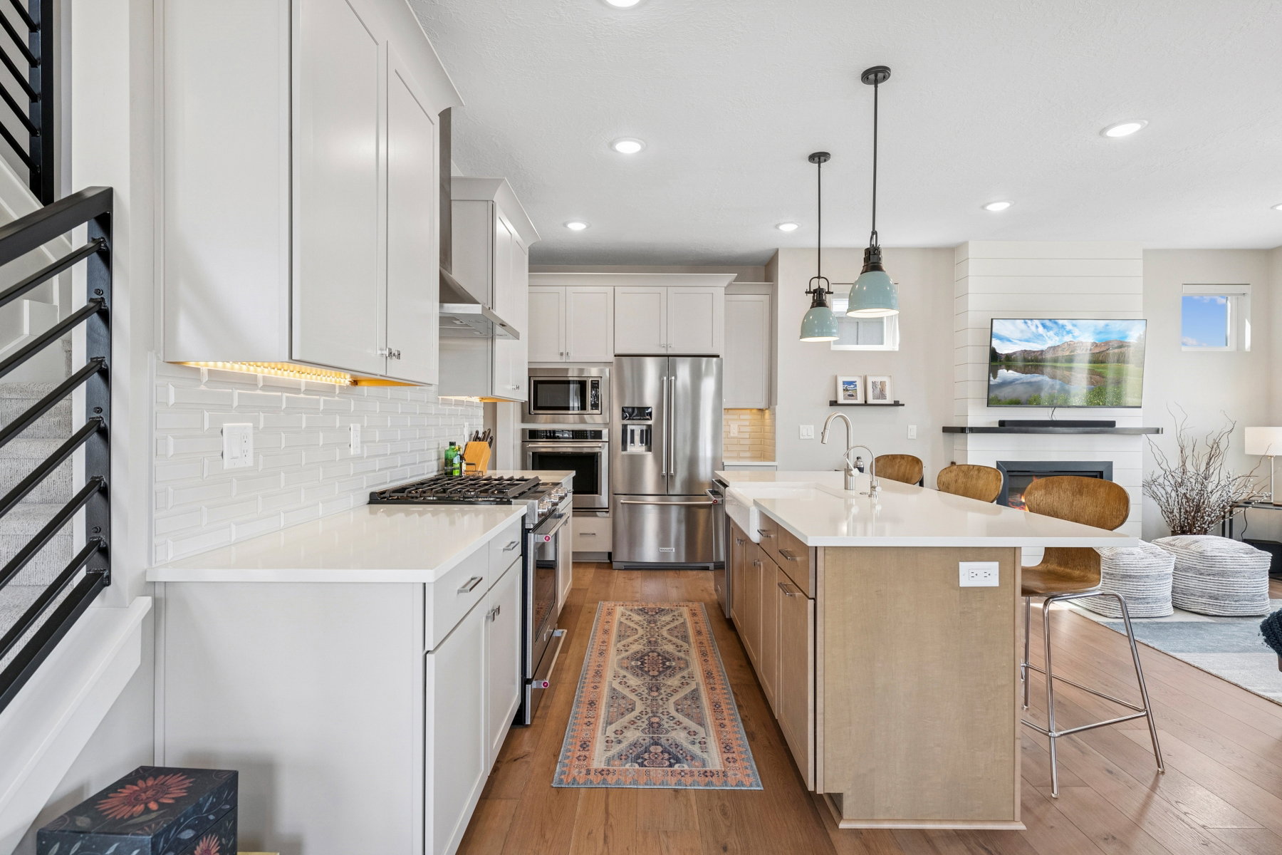 Kitchen with two tone color scheme, a breakfast bar, stainless steel appliances, open floor plan, and a center island with sink