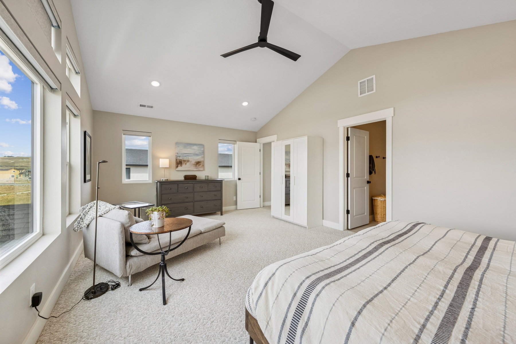 Bedroom with light colored carpet, lofted ceiling, ceiling fan, and recessed lighting