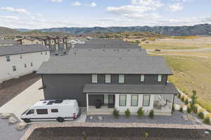 Back of property featuring roof with shingles and a mountain view