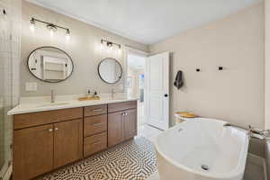 Bathroom with a freestanding tub, double vanity, and light tile patterned floors